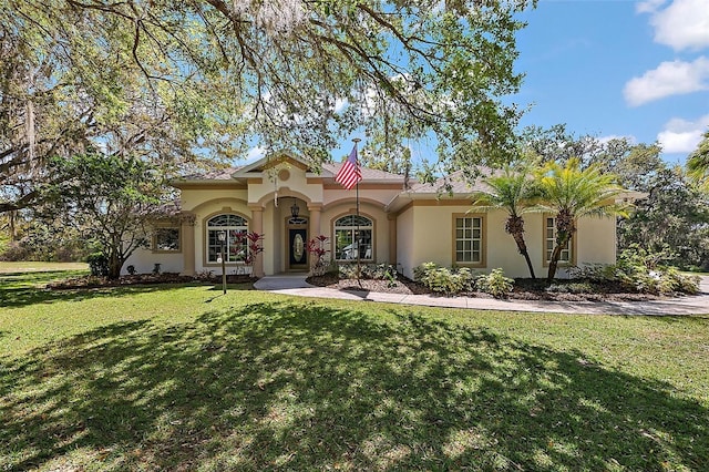 mediterranean / spanish-style house with stucco siding and a front yard