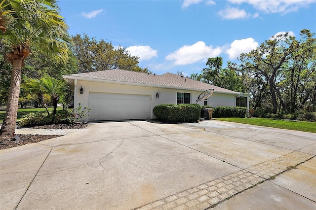 ranch-style house with an attached garage, driveway, and stucco siding