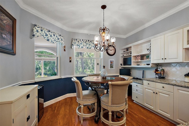 dining area with dark wood finished floors, a chandelier, crown molding, and baseboards