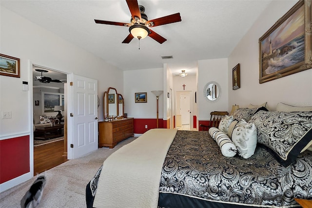 carpeted bedroom with visible vents and ceiling fan