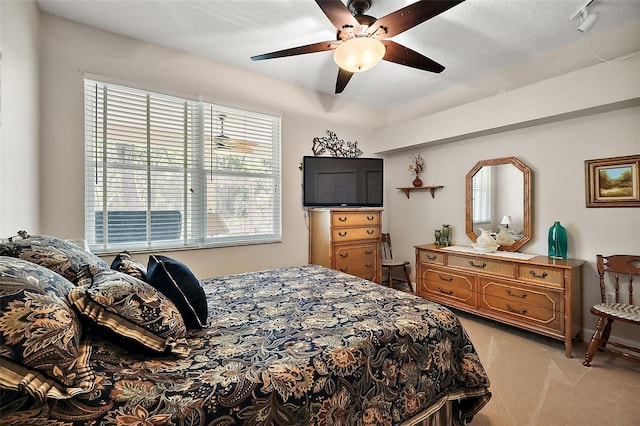 bedroom featuring multiple windows, light colored carpet, and ceiling fan