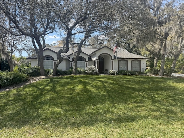 view of front of home with stucco siding and a front yard