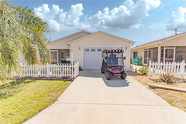 view of front of house with a garage, a sunroom, concrete driveway, and fence