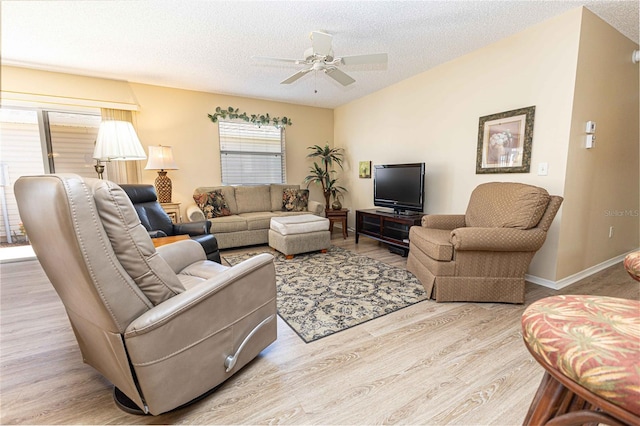 living room featuring baseboards, wood finished floors, a textured ceiling, and ceiling fan