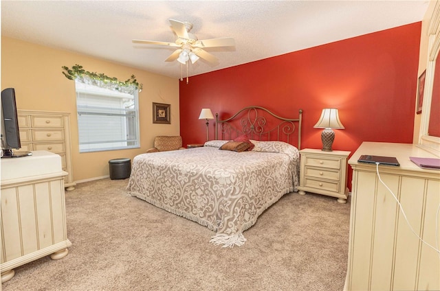 bedroom featuring baseboards, light colored carpet, ceiling fan, and an accent wall