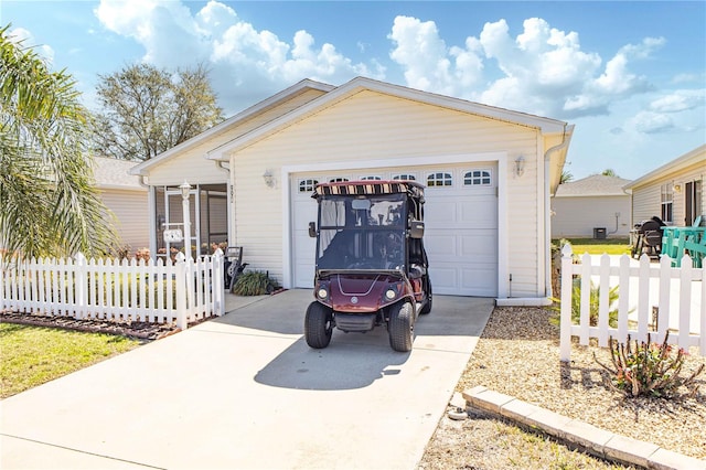 view of front of home with concrete driveway, fence, and a garage