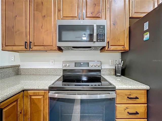 kitchen with brown cabinetry and appliances with stainless steel finishes