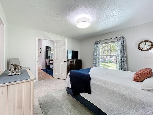 bedroom featuring a textured ceiling and light tile patterned flooring