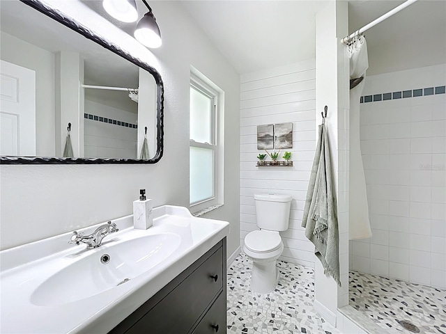 full bathroom featuring tile patterned floors, tiled shower, toilet, and vanity