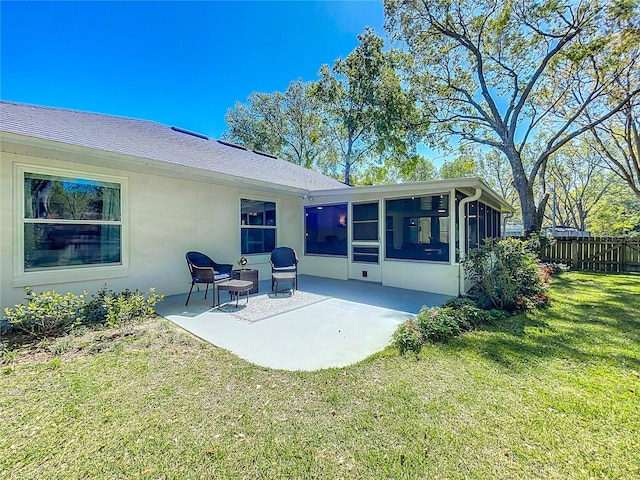 back of house featuring fence, stucco siding, a yard, a sunroom, and a patio area