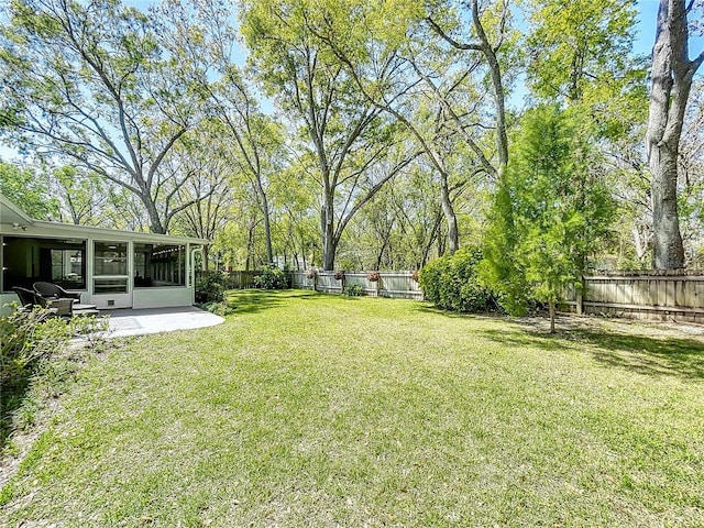 view of yard with a fenced backyard and a sunroom