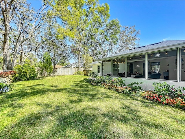 view of yard featuring fence and a sunroom