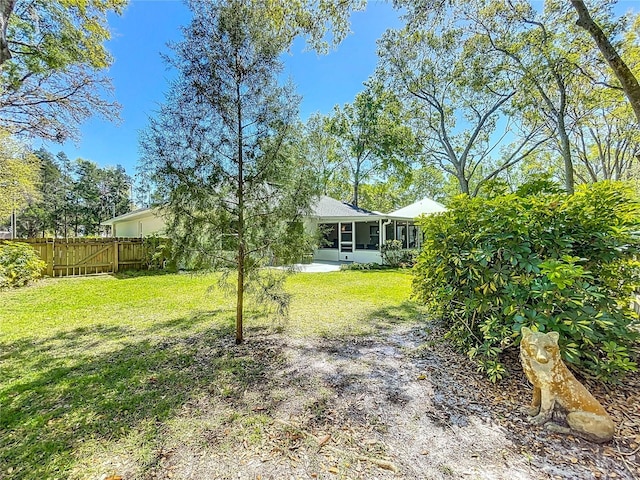 view of yard with fence and a sunroom