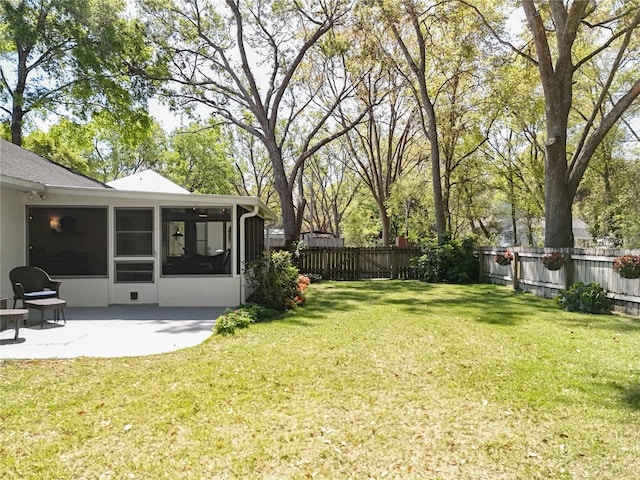 view of yard featuring a patio, a fenced backyard, and a sunroom