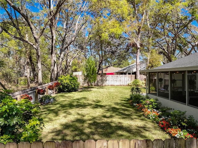 view of yard with a fenced backyard and a sunroom