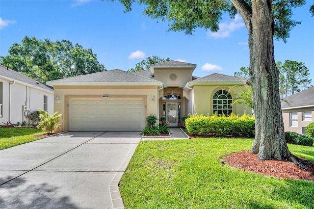 mediterranean / spanish home featuring a front lawn, concrete driveway, roof with shingles, stucco siding, and a garage