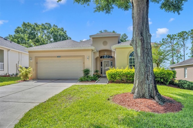 mediterranean / spanish-style home with stucco siding, driveway, a front yard, and a garage