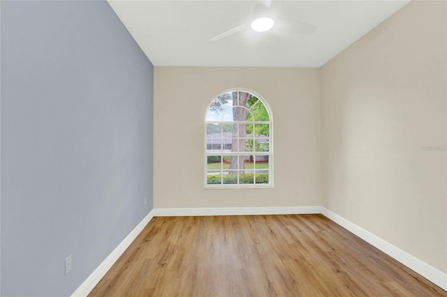 unfurnished room featuring baseboards, light wood-style floors, and a ceiling fan