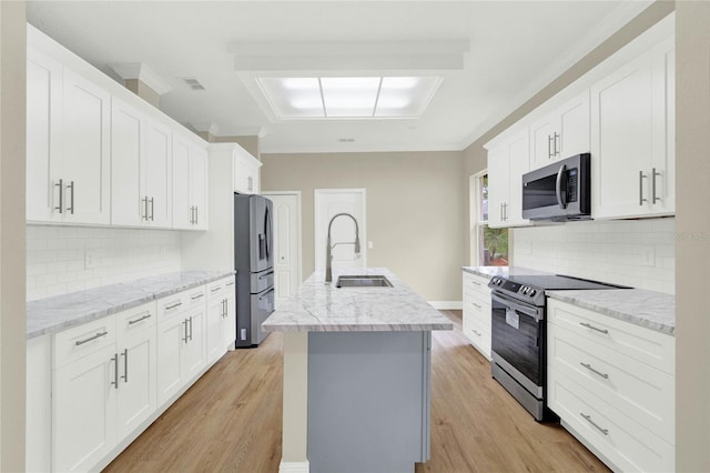 kitchen with visible vents, a sink, light wood-style floors, appliances with stainless steel finishes, and white cabinets