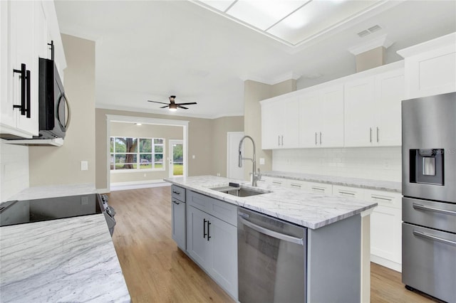 kitchen featuring white cabinetry, light wood-type flooring, appliances with stainless steel finishes, and a sink