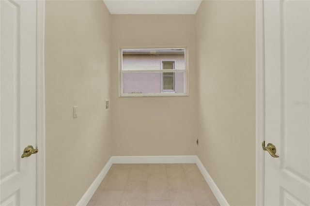 washroom featuring laundry area, hookup for a washing machine, light tile patterned floors, and baseboards