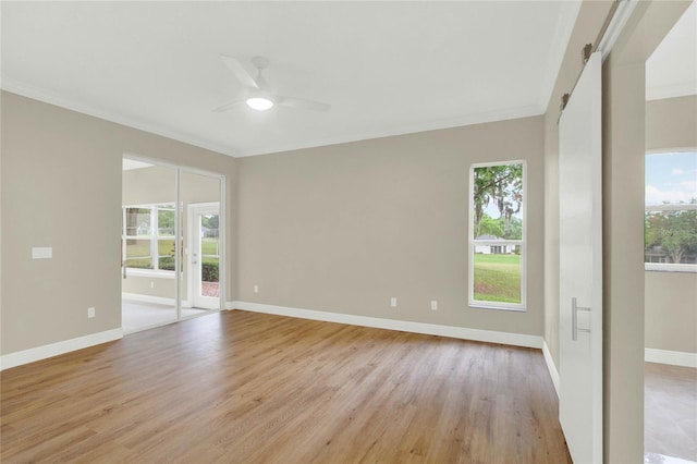 unfurnished room featuring light wood-type flooring, baseboards, ornamental molding, and a ceiling fan