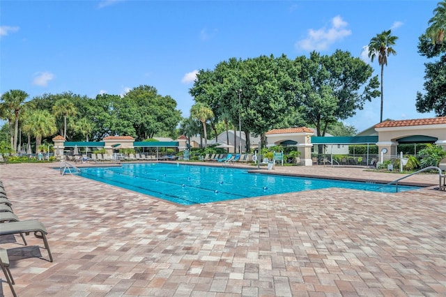 pool with a patio area and fence