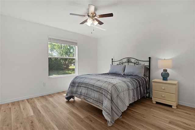 bedroom featuring ceiling fan, light wood-type flooring, and baseboards