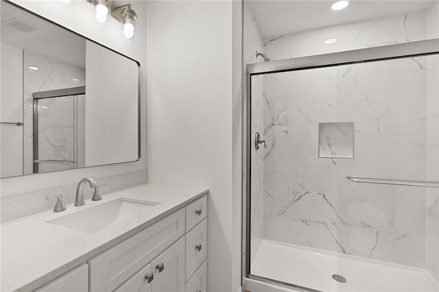 bathroom featuring a marble finish shower, visible vents, and vanity