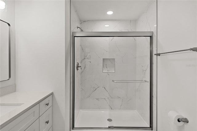 bathroom with a marble finish shower and vanity