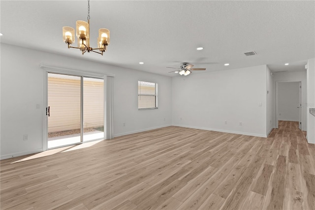 empty room featuring light wood-style flooring, recessed lighting, ceiling fan with notable chandelier, and visible vents