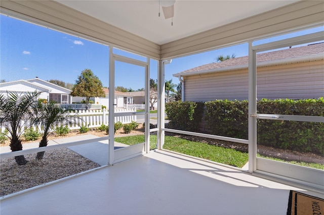 unfurnished sunroom with a ceiling fan