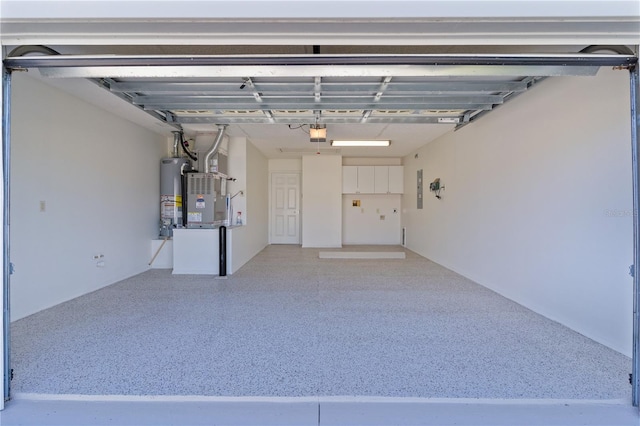 garage featuring gas water heater, heating unit, electric panel, and a garage door opener