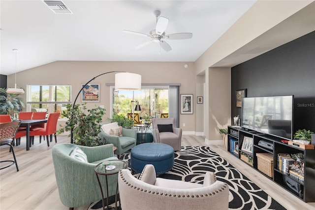 living room with wood finished floors, a ceiling fan, visible vents, baseboards, and lofted ceiling