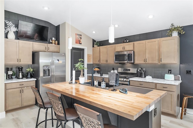 kitchen with stainless steel appliances, wooden counters, a kitchen bar, and decorative backsplash