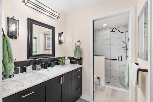 full bath with vanity, toilet, tasteful backsplash, and a stall shower