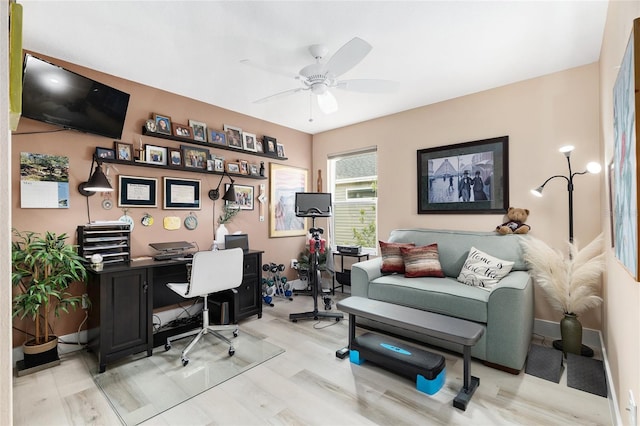 office space with light wood finished floors, baseboards, and ceiling fan