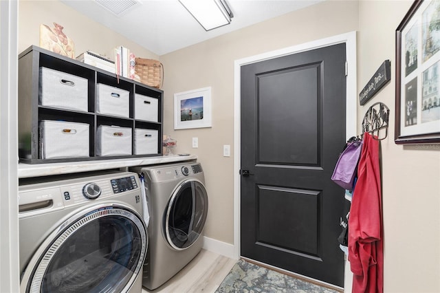 laundry room with visible vents, baseboards, washing machine and dryer, laundry area, and light wood-style flooring