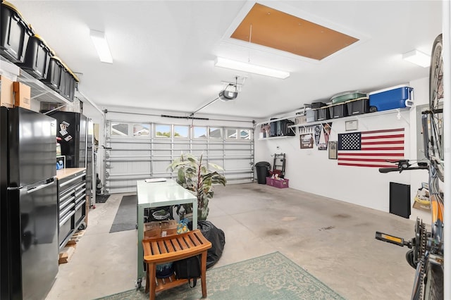 garage featuring a garage door opener and freestanding refrigerator