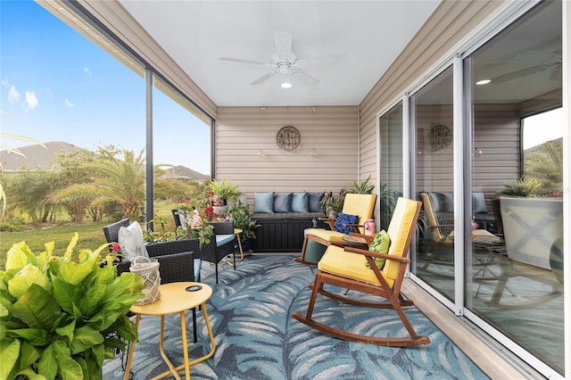 sunroom / solarium featuring a ceiling fan