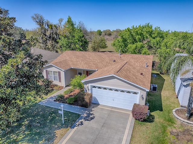 view of front of property featuring a garage, roof with shingles, concrete driveway, and a front lawn