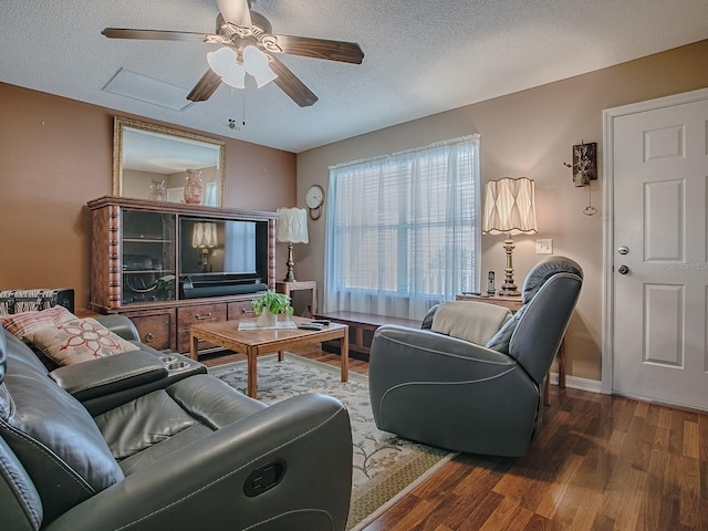 living area featuring ceiling fan, baseboards, a textured ceiling, and wood finished floors