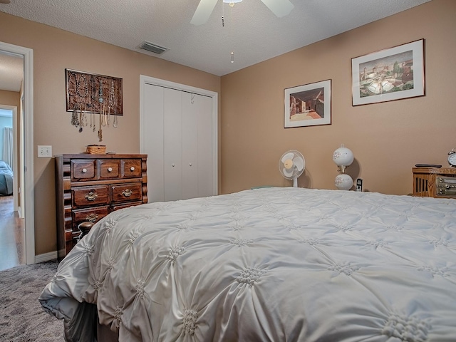 bedroom featuring visible vents, a textured ceiling, a closet, and ceiling fan