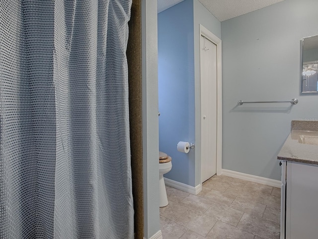 bathroom featuring tile patterned floors, toilet, vanity, and baseboards