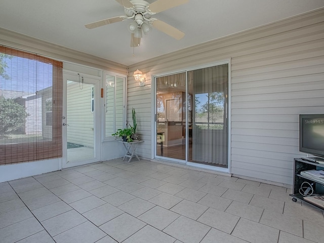 unfurnished sunroom with ceiling fan