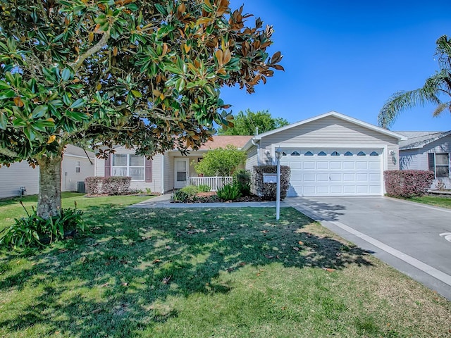 view of front of property with concrete driveway, an attached garage, cooling unit, and a front yard