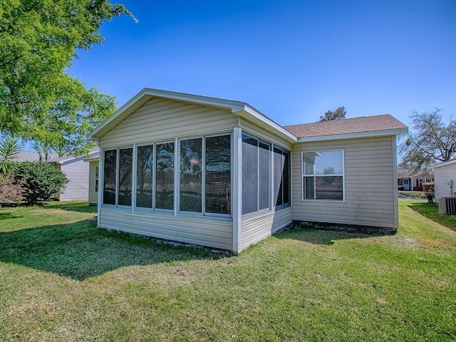 view of side of home featuring a lawn and a sunroom