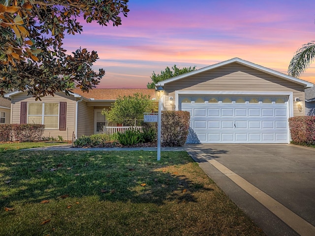 ranch-style home with a lawn and concrete driveway