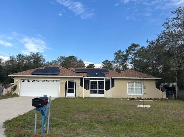 ranch-style home featuring a front yard, stucco siding, concrete driveway, a garage, and roof mounted solar panels