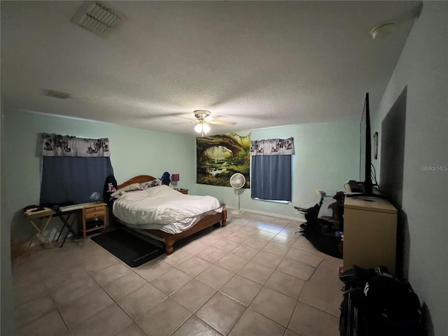 tiled bedroom featuring a ceiling fan, visible vents, and a textured ceiling